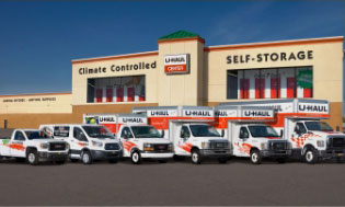 A fleet of U-Haul rental trucks in front of a U-Haul self-storage facility