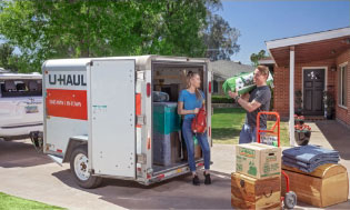 A fleet of U-Haul rental trucks in front of a U-Haul self-storage facility