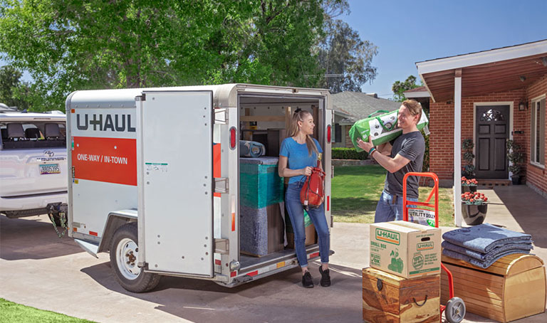A fleet of U-Haul rental trucks in front of a U-Haul self-storage facility