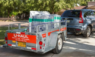 A fleet of U-Haul rental trucks in front of a U-Haul self-storage facility