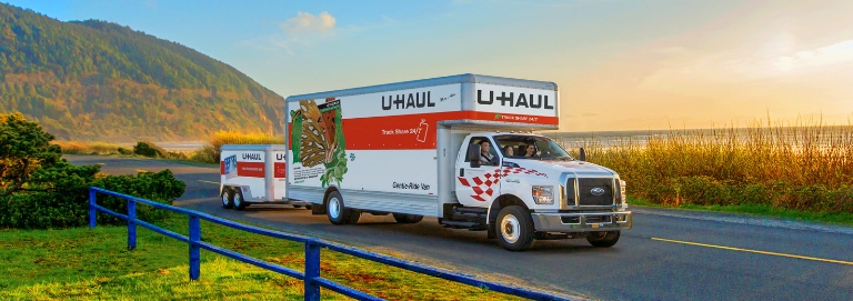 U-Haul Truck towing a trailer on a coastal road