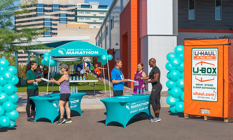 Employees using a UBox container to store equipment used for a marathon event.