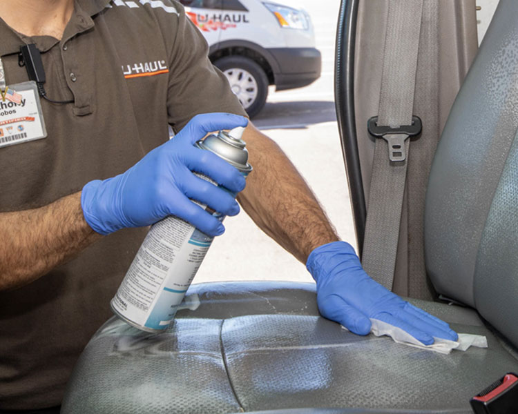 U-Haul center employee sanitizing the interior of a moving truck