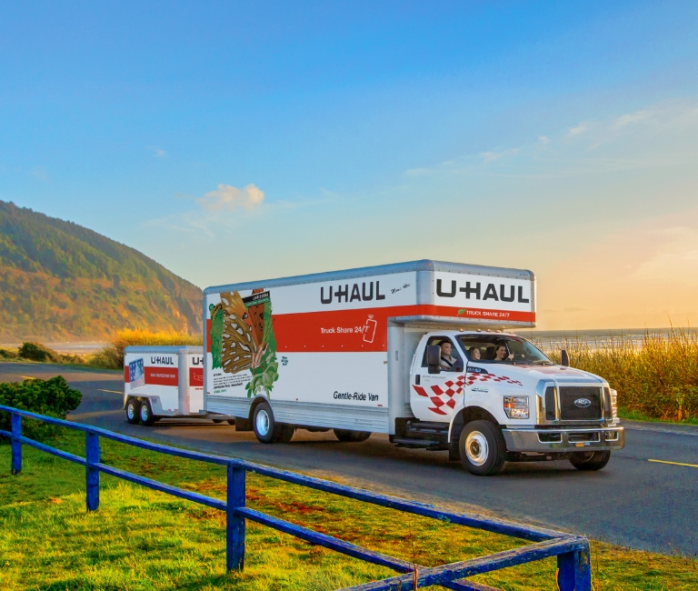 U-Haul Truck towing a trailer on a coastal road