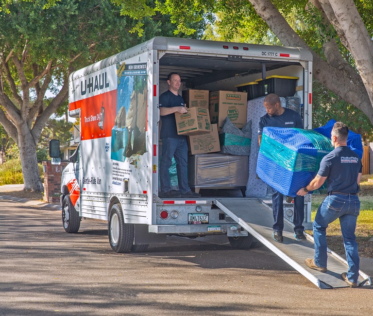 Moving Help service providers loading furniture and boxes into a U-Haul moving truck
