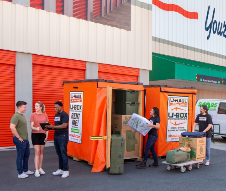 Military family loading their belongings into a U-Box container at a U-Haul Moving and Storage facility