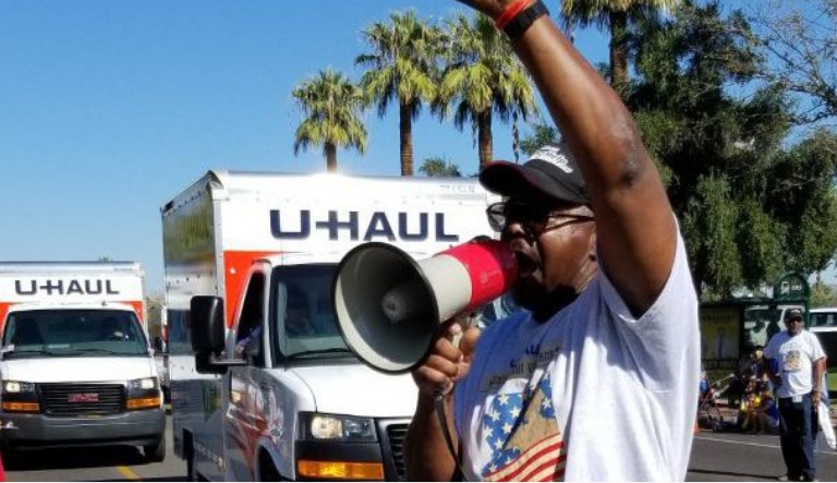 A U-Haul employee marching in the 2019 Phoenix Veterans Day Parade, voicing his support for our Veterans and Troops with a bullhorn