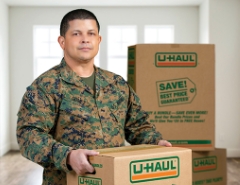 Military service member holding a U-Haul moving box
