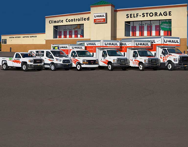 U-Haul truck fleet parked in front of a U-Haul storage facility