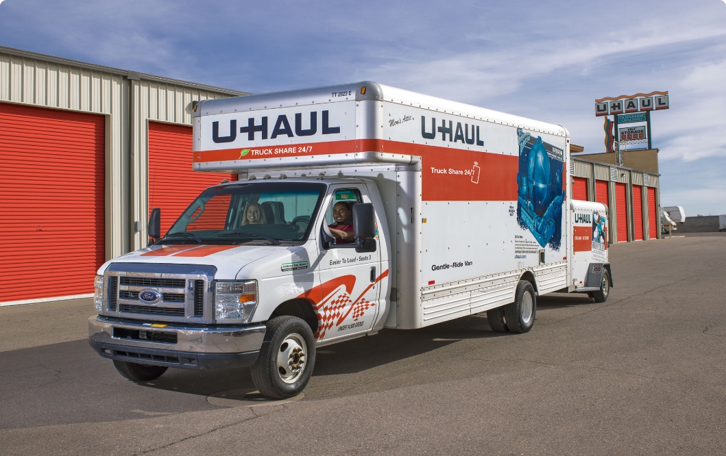 Un camión de U-Haul estacionado al lado de unidades de almacenamiento