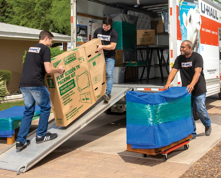 Proveedores de servicio de Moving Help® cargando muebles pesados en un U-Box® con clientes