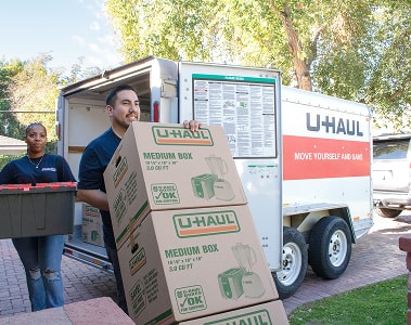 Moving helpers unloading a U-Haul moving truck