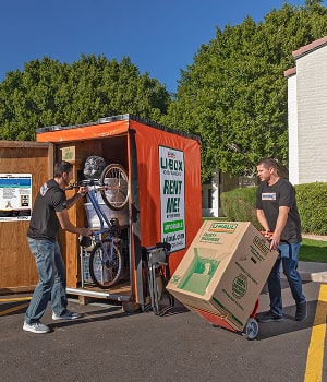 Moving Helpers loading a bicycle and boxes into a U-Box container