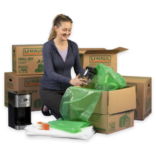 A woman packing moving boxes