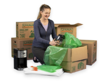 A woman packing moving boxes