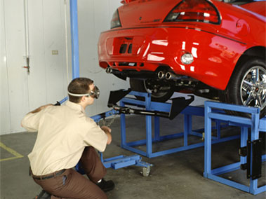 A mechanic installing a trailer hitch.