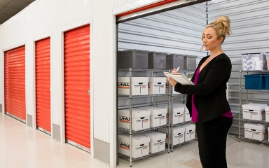 A woman taking inventory of a business storage container