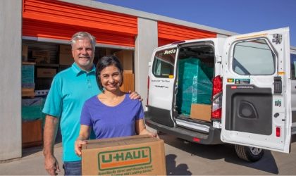 Des propriétaires de maison chargeant des boîtes dans un camion de location à partir d'une unité d'entreposage
