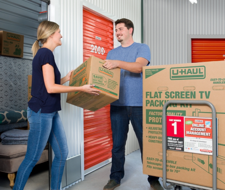 Couple loading boxes into a self storage container