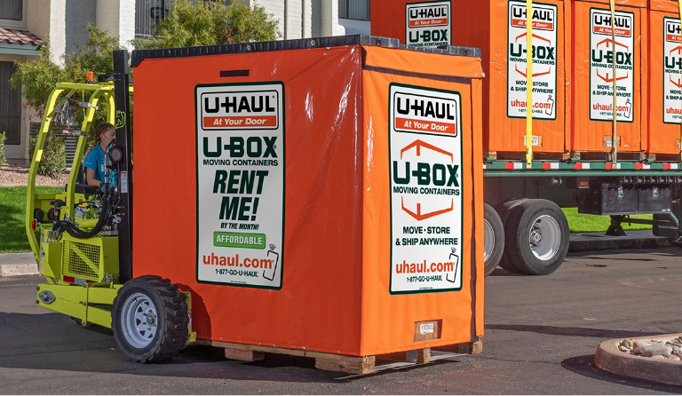 Couple Loading A U Box Container In Their Driveway